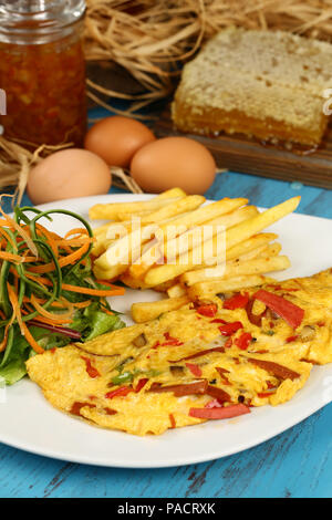 Breakfast omelette with french fries and garnish Stock Photo