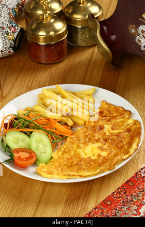 Breakfast omelette with french fries and garnish Stock Photo