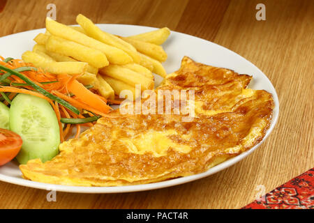 Breakfast omelette with french fries and garnish Stock Photo