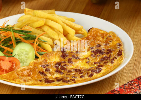 Breakfast omelette with french fries and garnish Stock Photo