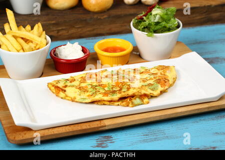 Breakfast omelette with french fries and garnish Stock Photo