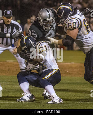 Oakland, California, USA. 11th Sep, 2006. Oakland Raiders defensive end  Tommy Kelly (93) attempts to tackle San Diego Chargers running back LaDainian  Tomlinson (21) while holding off Chargers guard Kris Dielman (68) on  Monday, September 11