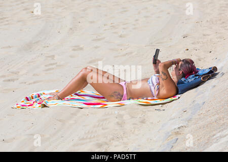 Bournemouth, Dorset, UK. 22nd July 2018. UK weather: hot and sunny at Bournemouth beaches, as sunseekers head to the seaside to soak up the sun. Woman sunbathing on beach.  Credit: Carolyn Jenkins/Alamy Live News Stock Photo