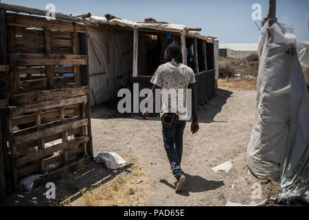 Nijar, Spain. 21st July, 2018. 21.07.2018, Spain, Almería, Nijar: A migrant walks to his hut in a permanet settlement near Nijar, Almeria, Spain; Over 50 african undocumented migrants live in poor conditions while hoping to get some work on the nearby plantations. Credit: Javier Fergo/dpa/Alamy Live News Stock Photo