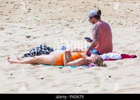 Bournemouth, Dorset, UK. 22nd July 2018. UK weather: hot and sunny at Bournemouth beaches, as sunseekers head to the seaside to soak up the sun. Couple sunbathing on the beach. Credit: Carolyn Jenkins/Alamy Live News Stock Photo
