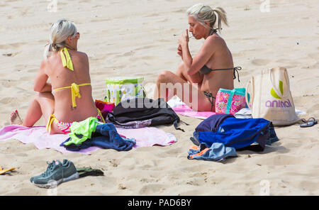 Bournemouth, Dorset, UK. 22nd July 2018. UK weather: hot and sunny at Bournemouth beaches, as sunseekers head to the seaside to soak up the sun. Two women sunbathing on beach. Credit: Carolyn Jenkins/Alamy Live News Stock Photo