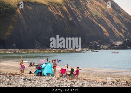 Clarach Bay,  Wales UK, Sunday 22 July 2018  UK Weather: People enjoying themselves on the beach at Clarach Bay near Aberystwyth on a gloriously sunny Sunday afternoon in west wales.  The UK wide heatwave continues, with no respite from the very dry weather and temperatures are expected to exceed 30ºc again by the end of the week  Photo credit: Keith Morris / Alamy Live News