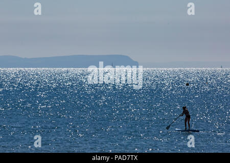 Bournemouth, Dorset, UK. 22nd July 2018. UK weather: hot and sunny at Bournemouth beaches, as sunseekers head to the seaside to soak up the sun. Contre jour - silhouette of paddleboarder shooting into the sun. Credit: Carolyn Jenkins/Alamy Live News Stock Photo