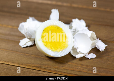 Half a hardboiled egg with the shells laying on the kitchen table Stock Photo