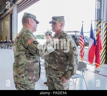 Maj. Gen. Samuel L. Henry, commander, 36th Infantry Division, presents Col. Ronald W. Burkett II, outgoing commander, 36th Combat Aviation Brigade, the Legion of Merit during a change of command ceremony, Austin, Texas, July 14, 2018. (Texas Army National Guard Photo by 2nd Lt. Caitlin Rourk) Stock Photo