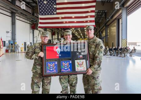 Chief Warrant Officer 5 Douglas W. Phillips, command chief warrant officer, 36th CAB, and Command Sgt. Maj. Robert W. Hartzog, present Col. Ronald W. Burkett II, outgoing commander, 36th CAB, a goodbye present during a change of command, Austin, Texas, July 14, 2018. (Texas Army National Guard Photo by 2nd Lt. Caitlin Rourk) Stock Photo