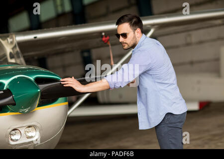 Handsome young pilot checking ultralight airplane before flight Stock Photo