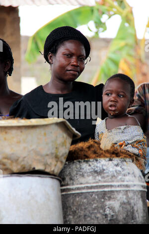 African woman and her baby at a palm oil factory near Cape Coast, Ghana Stock Photo