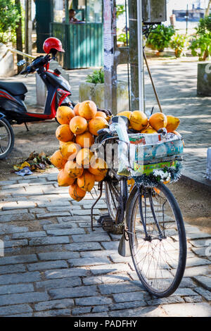 Local lifestyle: Bicycle loaded with yellow king coconuts for sale on the roadside in historic Galle Fort, Galle, Southern Province, Sri Lanka Stock Photo