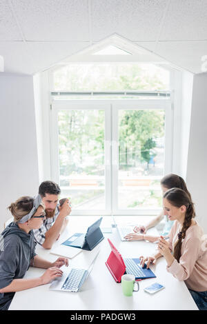 Dedicated young woman editing a document in a modern office space Stock Photo