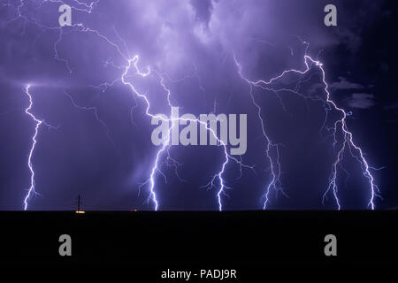 Lightning bolts strike and illuminate the night sky as a summer monsoon thunderstorm moves across the desert near Willcox, Arizona Stock Photo