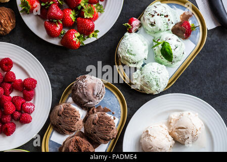 Selection of different ice cream scoops such as mint, chocolate and strawberry on marble background, top view Stock Photo