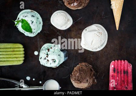 Selection of different ice cream scoops such as mint, chocolate and strawberry on dark background, top view Stock Photo