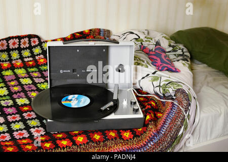 record player with spinning record in bedroom setting Stock Photo