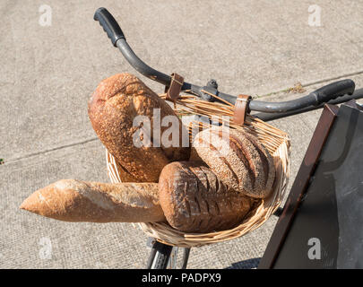 Artisan bread within a bicycle wicker basket Stock Photo