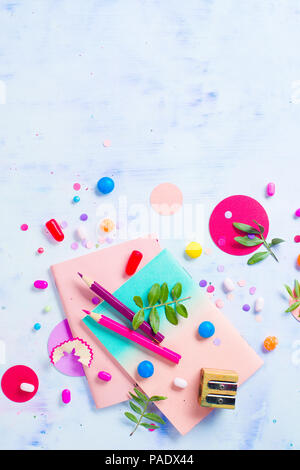 Colorful notebooks with macaroon cookies and confetti on a light background with copy space. Pink and purple palette flat lay. Stock Photo