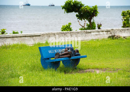 GABON - MARCH 6, 2013: Unidentified Gabonese homeless man sleeps on a bench in Gabon, Mar 6, 2013. People of Gabon suffer of poverty due to the unstab Stock Photo