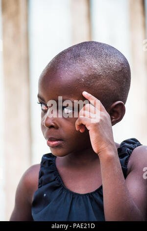 LIBREVILLE, GABON - MAR 6, 2013: Portrait of an Unidentified Gabonese serious little girl without hair in Gabon, Mar 6, 2013. People of Gabon suffer o Stock Photo