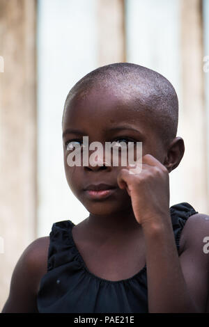 LIBREVILLE, GABON - MAR 6, 2013: Portrait of an Unidentified Gabonese serious little girl without hair in Gabon, Mar 6, 2013. People of Gabon suffer o Stock Photo