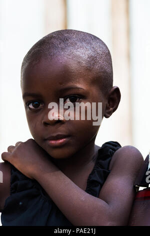 LIBREVILLE, GABON - MAR 6, 2013: Portrait of an Unidentified Gabonese serious little girl without hair in Gabon, Mar 6, 2013. People of Gabon suffer o Stock Photo