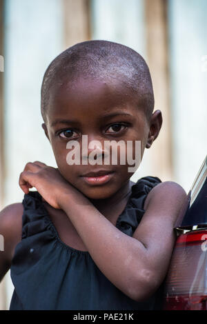 LIBREVILLE, GABON - MAR 6, 2013: Portrait of an Unidentified Gabonese serious little girl without hair in Gabon, Mar 6, 2013. People of Gabon suffer o Stock Photo