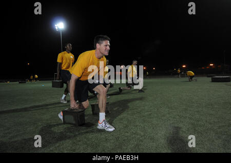 Assistant Secretary of the Navy for Manpower and Reserve Affairs Juan M. Garcia performs weighted lunges during an early morning physical training session with Naval Mobile Construction Battalion 3 at Camp Lemonnier. Garcia visited Camp Lemonnier to promote the 21st Century Sailor and Marine Initiative. The initiative consolidates a set of objectives and policies to maximize sailor and Marine personal readiness, build resiliency and hone the most combat-effective force in the history of the Department of the Navy. Stock Photo