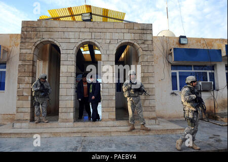 U.S. Soldiers from 2nd Platoon, 218th Military Police Company, 317th Military Police Battalion, 49th Military Police Brigade, 3rd Infantry Division, stand guard outside Altun Kupri Iraqi Police Station, Iraq, Jan. 3. The Soldiers visited the police station to talk discuss current events and training issues for the Iraqi police. Stock Photo