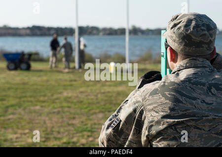 U.S. Air Force Staff Sgt. Seth Johnson, a structural craftsman assigned to the 633rd Civil Engineer Squadron, checks the plum of new flag posts at Memorial Park at Langley Air Force Base, Va., March 24, 2016. Johnson ensured each post was level and not leaning to either side. (U.S. Air Force photo by Airman 1st Class Derek Seifert) Stock Photo