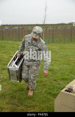 Cooks from the Wiesbaden Strong Teams Cafe Dining Facility (DFAC) brought a Mobile Kitchen Trailer (MKT) out to the Wackernheim Regional Range Facility on 30 March 2016 to feed the U.S. Army Europe Soldiers. Cook, Spc. Michelle Santiago-Lopez, carries a burner she just field with diesel for the set up of the MKT, prepared the meals, fed the Soldiers, cleaned the MKT, and broke down the trailer to be used next time. After a long period of not being used, this is the first time the MKT has been set up to be used by the cooks for the Soldiers, it was a great opportunity for Ssg. King to teach the Stock Photo