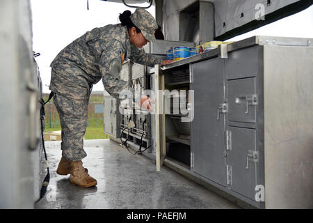 Cooks from the Wiesbaden Strong Teams Cafe Dining Facility (DFAC) brought a Mobile Kitchen Trailer (MKT) out to the Wackernheim Regional Range Facility on 30 March 2016 to feed the U.S. Army Europe Soldiers. Here Spc. Michelle Santiago-Lopez whom assisted in preparing the meals is looking for a serving utensil to use. The MKT is compact, but everything has a place inside it. After a long period of not being used, this is the first time the MKT has been set up to be used by the cooks for the Soldiers. (U.S. Army Photo by Visual Information Specialist Dee Crawford/Released) Stock Photo
