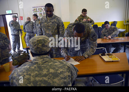 Soldiers from U.S. Army Europe Headquarters & Headquarters Company sign in so they can get some chow from the food prepared by the Cooks from the Wiesbaden Strong Teams Cafe Dining Facility (DFAC). The Cooks brought a Mobile Kitchen Trailer (MKT) out to the Wackernheim Regional Range Facility on 30 March 2016 to feed the U.S. Army Europe Soldiers. The three cooks, (NCO Ssg. Raymond King, and Spc. Michelle Santiago-Lopez, and Spc. Kallan Clements) and one grill mechanic (Spc. Luke Wilson), set up the MKT, prepared the meals, fed the Soldiers, cleaned the MKT, and broke down the trailer to be us Stock Photo