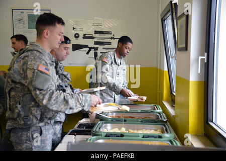 Soldiers from U.S. Army Europe Headquarters & Headquarters Company serve up some chow from the food prepared by the Cooks from the Wiesbaden Strong Teams Cafe Dining Facility (DFAC). The Cooks brought a Mobile Kitchen Trailer (MKT) out to the Wackernheim Regional Range Facility on 30 March 2016 to feed the U.S. Army Europe Soldiers. The three cooks, (NCO Ssg. Raymond King, and Spc. Michelle Santiago-Lopez, and Spc. Kallan Clements) and one grill mechanic (Spc. Luke Wilson), set up the MKT, prepared the meals, fed the Soldiers, cleaned the MKT, and broke down the trailer to be used next time. A Stock Photo