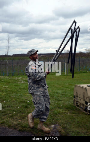 Cooks from the Wiesbaden Strong Teams Cafe Dining Facility (DFAC) brought a Mobile Kitchen Trailer (MKT) out to the Wackernheim Regional Range Facility on 30 March 2016 to feed the U.S. Army Europe Soldiers.Spc. Kallan Clements carries tent poles back to the MKT to pack up. (U.S. Army Photo by Visual Information Specialist Dee Crawford/Released) Stock Photo