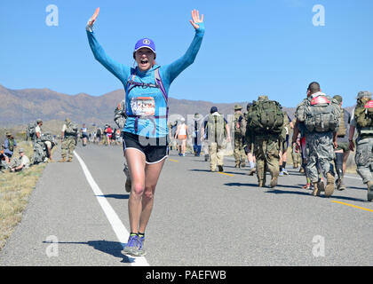 A participant during the Bataan Memorial Death March makes her way toward the finish line at White Sands Missile Range, New Mexico, March 20, 2016. The Bataan Memorial Death March honors a special group of World War II heroes. These service members were responsible for the defense of the islands of Luzon, Corregidor and the harbor defense forts of the Philippines. On April 9, 1942, tens of thousands of American and Filipino service members surrendered to Japanese Forces,and were then marched for days through the Philippine jungles. In honor of their sacrifice, more than 6,500 people participat Stock Photo