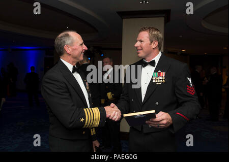 Chief of Naval Operations (CNO) Adm. Jonathan Greenert extends a small personal gift to Explosive Ordnance Disposal Technician 1st Class Troy A. Comer at the 2014 USO annual Gala where senior Department of Defense leadership and civic leaders gathered to honor the service of the many men and women in uniform, their families and the 29,000 volunteers who make up the USO. Exceptional service members from each branch of service were honored during the evening and this year's USO Sailor of the Year honoree is Comer for saving the lives of service members through bomb neutralization techniques in A Stock Photo