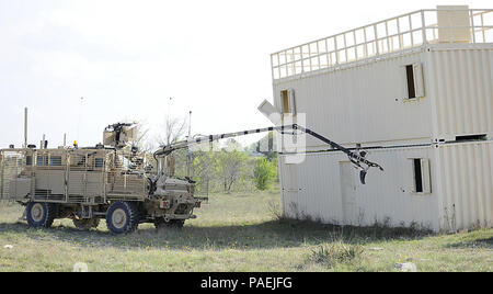 FORT HOOD, Texas — Soldiers of the 510th Route Clearance Platoon, 20th Engineer Battalion, 36th Engineer Brigade use the Medium Mine Protected Vehicle, Type II (MMPV II) interrogation arm to remotely look into a training building without Soldiers having to dismount the vehicle. The arm provides the vehicle crew the ability to interrogate and manipulate suspected hazardous items during their clearance mission. The U.S. Army Operational Test Command gathers data from Soldiers operating the gear to determine whether or not the system meets the needs of a route clearance company’s mission.   (Phot Stock Photo