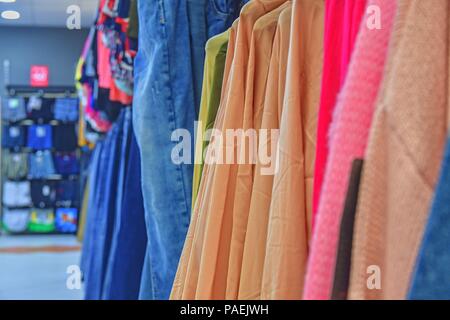 Clothes shop Costume dress. Fashion store. Style Concept. Colorful women's dresses on hangers in a retail shop. Fashion and shopping concept. Blurred  Stock Photo