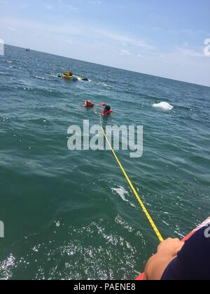 A Coast Guard Station Islamorada 33-foot Special Purpose Craft—Law Enforcement boatcrew pull two people to safety Saturday, July 14, 2018 from an capsized boat near Whale Harbor near Islamorada, Florida. The two people had no reported injuries. U.S. Coast Guard photo courtesy of Station Islamorada Stock Photo
