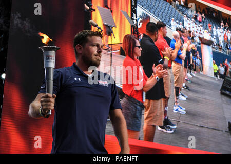 (July 1, 2017) Retired Hospital Corpsman 3rd Class and Team Navy Member Nate Hamilton holds the ceremonial torch after having lit the cauldron during the opening ceremony of the 2017 Warrior Games at Soldier Field in Chicago. Team Navy is comprised of athletes from Navy Wounded Warrior - Safe Harbor, the Navy's sole organization for coordinating the non-medical care of seriously wounded, ill, and injured Sailors and Coast Guard members, providing resources and support to their families. Stock Photo
