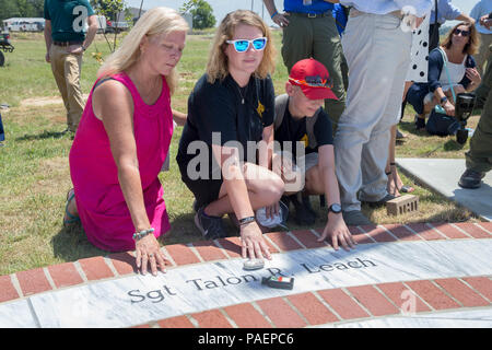 Family members pose next to the name of late Marine Sgt. Talon R. Leach, on a marble monument honoring the fallen Marines and sailor, lost in a 2017 plane crash near Itta Bena, Miss., Jul 14, 2018. More than 200 relatives and friends of the 16 people who died aboard the flight with the call sign Yanky 72, joined by countless county residents and military supporters at the ceremonies on campus of Mississippi Valley State University and across the street. (U.S. Marine Corps photo by Lance Cpl. Samantha Schwoch/released) Stock Photo