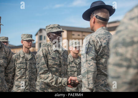 Gour Maker, a trainee at Air Force Basic Military Training, receives an “Airman’s Coin” at the Coin Ceremony Feb. 1, 2018 outside the Pfingston Reception Center at Joint Base San Antonio-Lackland, Texas. During the BMT Coin Ceremony Trainees are given “Airman’s Coins’ signifying the final transition from trainee to Airman. Stock Photo