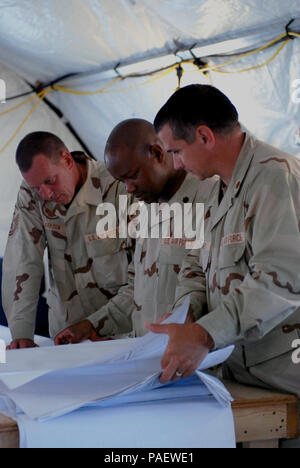 (From the left) Air Force 1st Sgt. Scott Clarkson, Lt. Col. Frederick Olson and Maj. Kevin McKinney from the 474th Expeditionary Civil Engineering Squadron examine blueprints in Camp Justice April 28. The 474th ECES is currently providing maintenance support for the Expeditionary Legal Complex where military commissions are being held. JTF Guantanamo conducts safe and humane care and custody of detained enemy combatants. The JTF conducts interrogation operations to collect strategic intelligence in support of the Global War on Terror and supports law enforcement and war crimes investigations.  Stock Photo