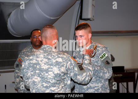 Army Capt. Christopher Hodl passes the 189th Military Police Company’s saber to Army 1st Sgt. Mark Tillman during a change of responsibility ceremony on U.S. Naval Station Guantanamo Bay, March 31, 2008. Tillman took over the company first sergeant position from Army 1st Sgt. Van Carpenter. JTF Guantanamo conducts safe and humane care and custody of detained enemy combatants. The JTF conducts interrogation operations to collect strategic intelligence in support of the Global War on Terror and supports law enforcement and war crimes investigations. JTF Guantanamo is committed to the safety and  Stock Photo