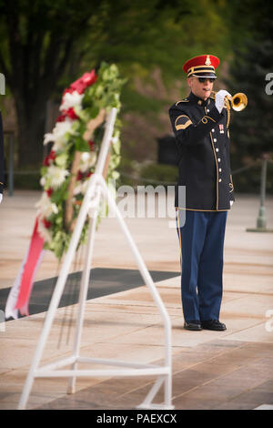 A bugler from The U.S. Army Band “Pershing’s Own” plays Taps during a wreath-laying ceremony with Minister Predrag Matic, not pictured, Republic of Croatia Minister of Veterans Affairs, at the Tomb of the Unknown Soldier in Arlington National Cemetery, April 30, 2015, Arlington, Va. Dignitaries from all over the world pay respects to those buried at Arlington National Cemetery in more than 3000 ceremonies each year. Stock Photo