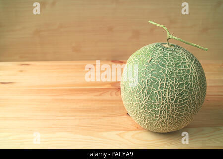 Fresh Ripe Cantaloupe Melon or Muskmelon Whole Fruit with Stem Isolated on Wooden Table Stock Photo